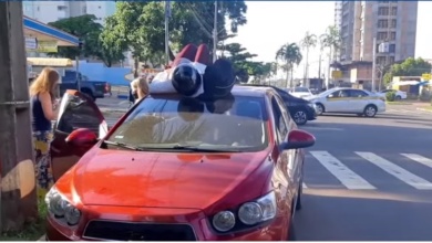 Foto de Passageira de motocicleta cai deitada sobre teto de carro após acidente