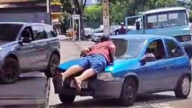 Foto de Homem deita sobre capô de carro para não deixar motorista fugir